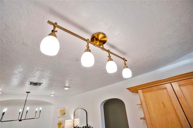 room details featuring a textured ceiling and an inviting chandelier