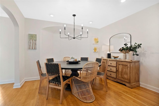 dining area with light wood-type flooring and a chandelier