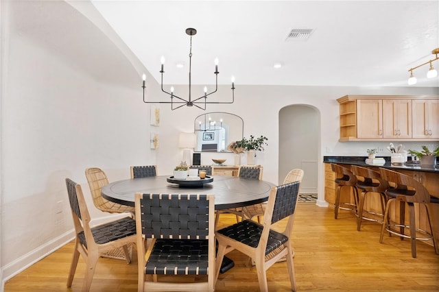 dining space featuring an inviting chandelier and light wood-type flooring