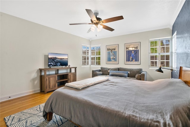 bedroom featuring light hardwood / wood-style floors, multiple windows, ornamental molding, and ceiling fan