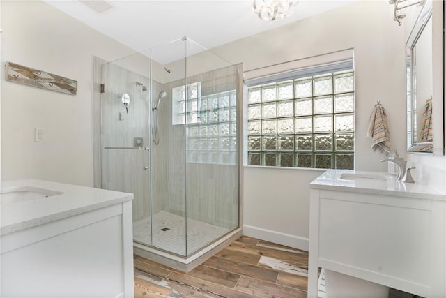 bathroom with hardwood / wood-style floors, vanity, and a shower with door