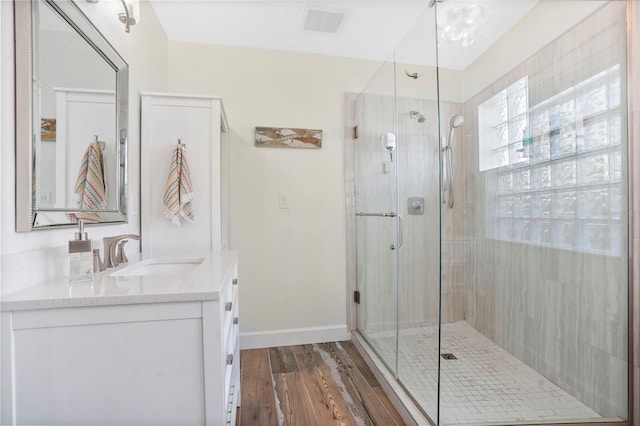 bathroom featuring hardwood / wood-style flooring, vanity, and an enclosed shower