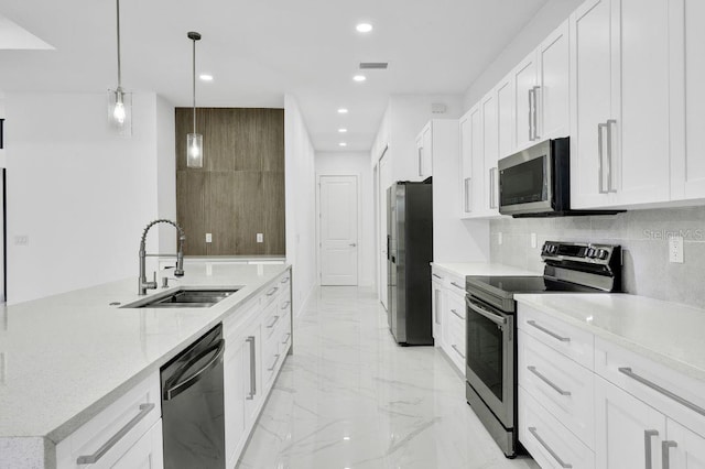 kitchen with hanging light fixtures, sink, white cabinets, and stainless steel appliances