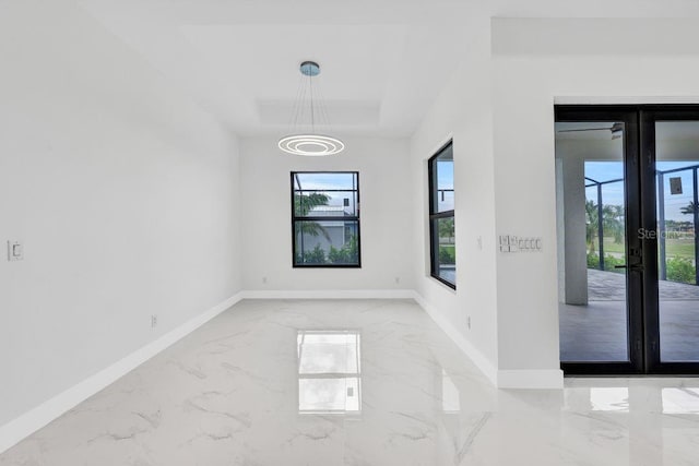 spare room with french doors and an inviting chandelier