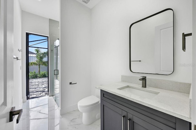 bathroom featuring vanity, toilet, and a shower with shower door