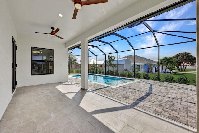 view of pool featuring glass enclosure, ceiling fan, and a patio area