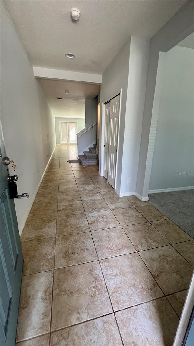 hall featuring light tile patterned floors