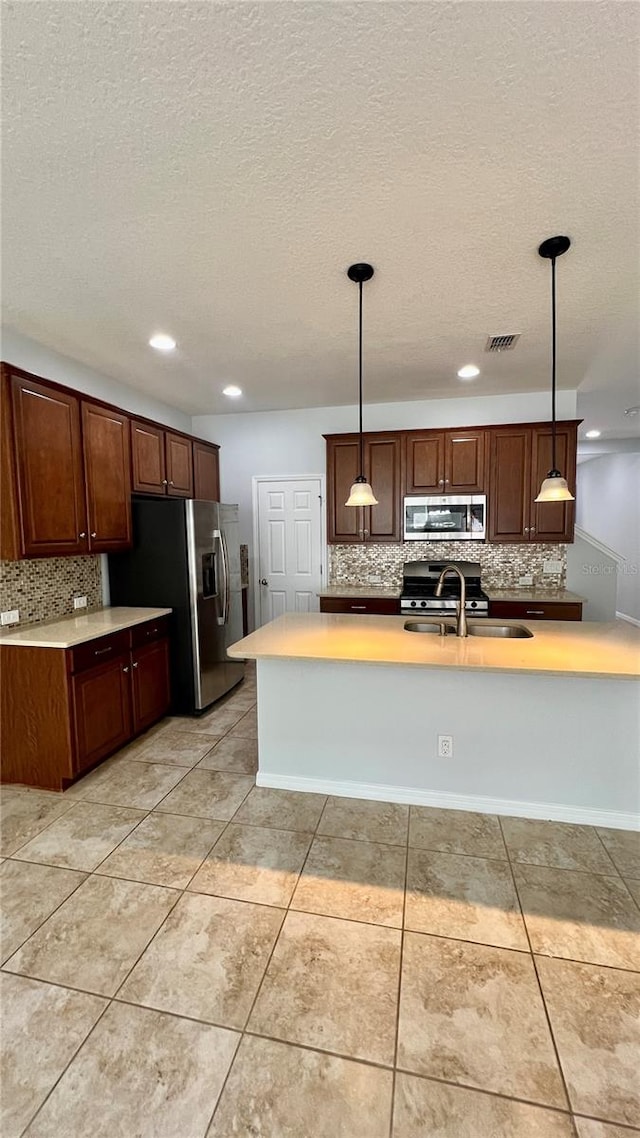 kitchen with decorative backsplash, light tile patterned flooring, decorative light fixtures, and stainless steel appliances