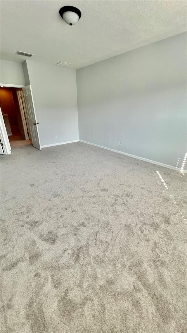 carpeted spare room featuring a textured ceiling