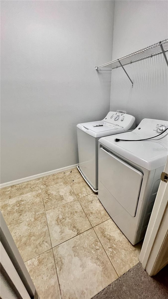 laundry area with independent washer and dryer and tile patterned floors