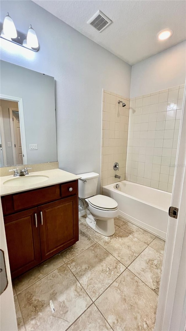 full bathroom with toilet, tile patterned flooring, tiled shower / bath combo, vanity, and a textured ceiling