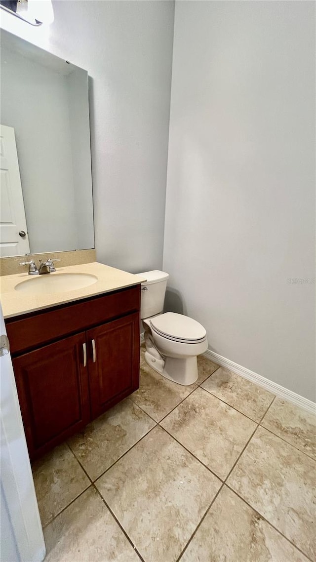 bathroom featuring vanity, toilet, and tile patterned flooring