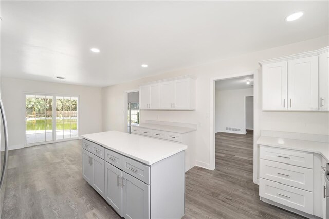 kitchen featuring light hardwood / wood-style flooring, a kitchen island, and white cabinets