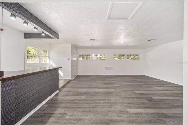 spare room with a textured ceiling and dark wood-type flooring