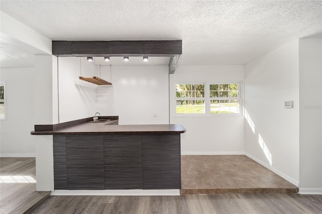 bar with sink, a textured ceiling, and hardwood / wood-style flooring