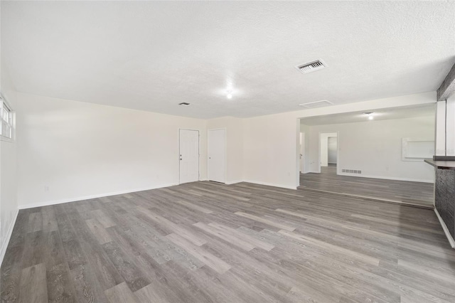 unfurnished living room featuring light hardwood / wood-style flooring and a textured ceiling