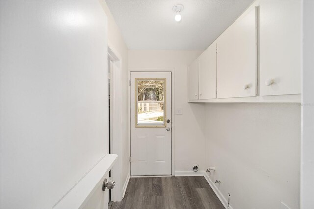 laundry room with dark wood-type flooring, cabinets, and gas dryer hookup