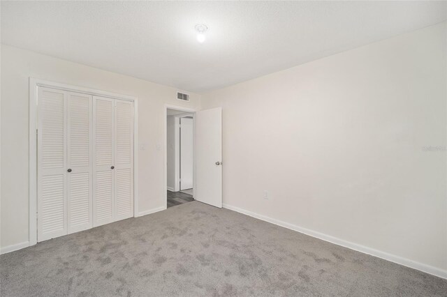 unfurnished bedroom with carpet flooring and a closet