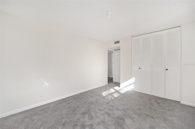 unfurnished bedroom featuring light carpet and a closet