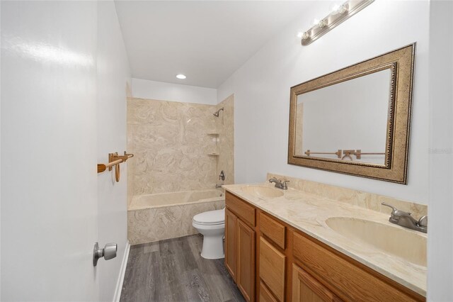 full bathroom with toilet, tiled shower / bath, vanity, and wood-type flooring