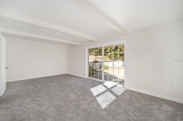 empty room with beam ceiling and carpet flooring