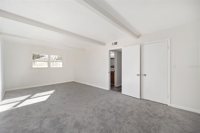 interior space with beam ceiling and dark colored carpet