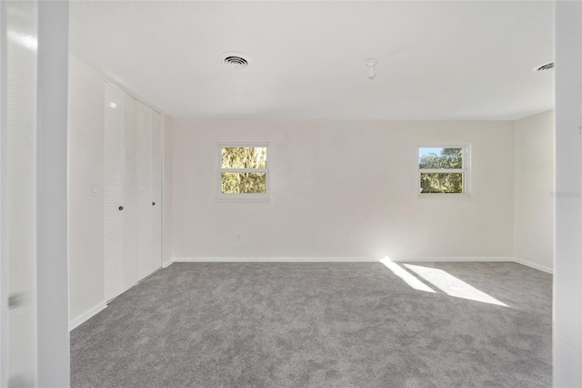 carpeted spare room with a healthy amount of sunlight