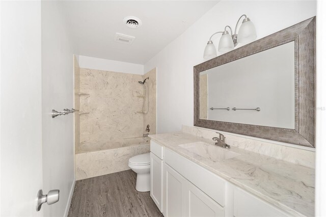 full bathroom with vanity, toilet, tiled shower / bath combo, and wood-type flooring