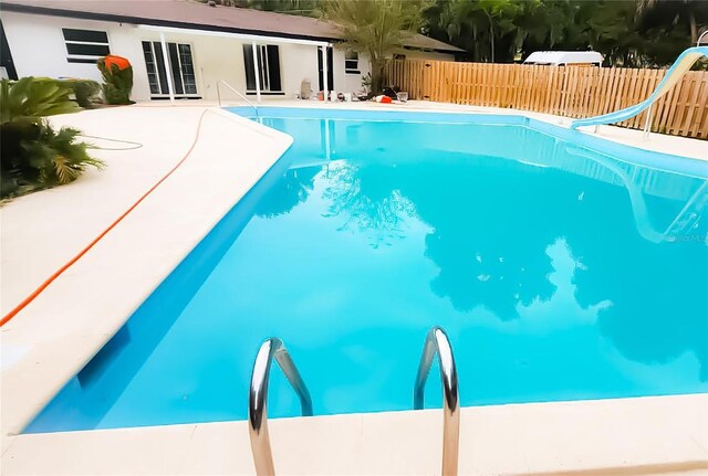 view of swimming pool featuring a patio and a water slide