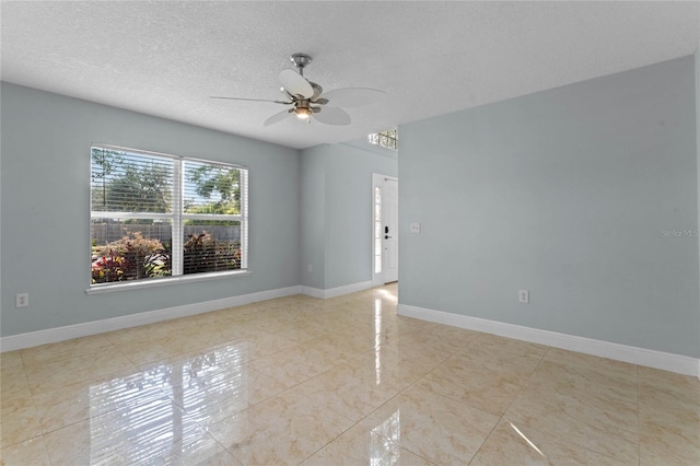 tiled empty room featuring ceiling fan and a textured ceiling