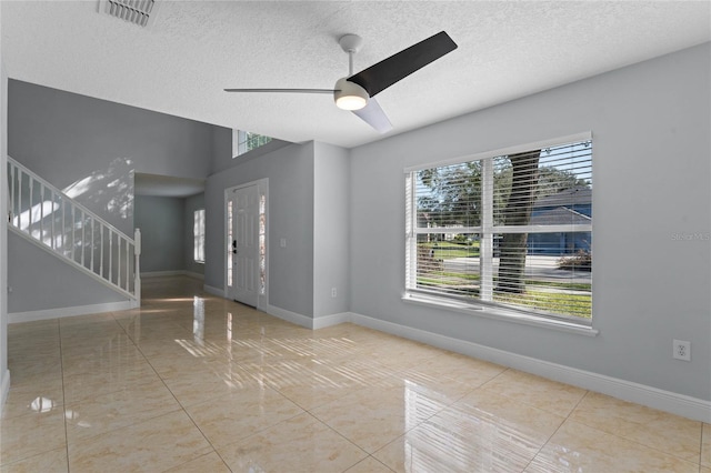 tiled spare room featuring ceiling fan and a textured ceiling