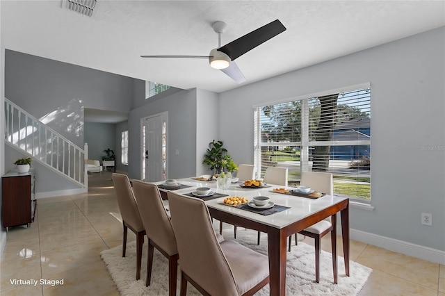 tiled dining space with ceiling fan and a wealth of natural light