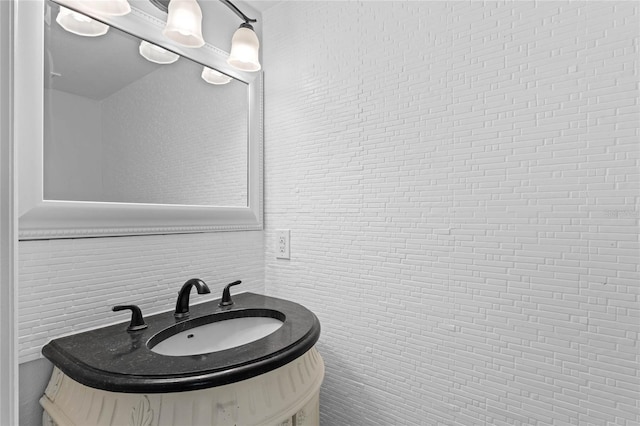 bathroom with vanity and brick wall