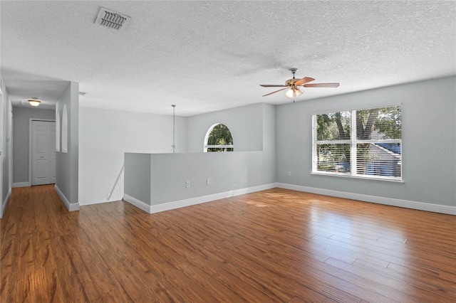 unfurnished room featuring a textured ceiling, wood-type flooring, and plenty of natural light