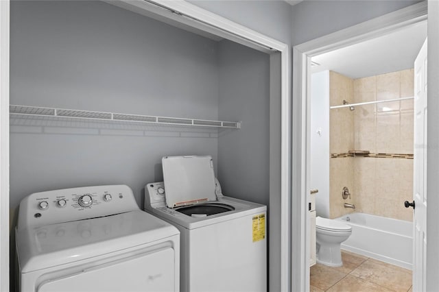 laundry room featuring light tile patterned flooring and washing machine and dryer