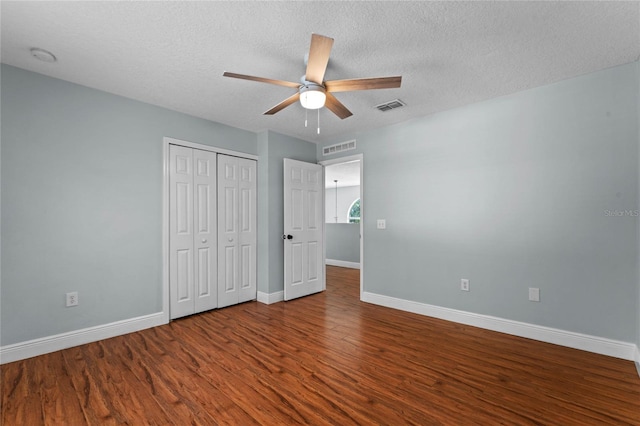 unfurnished bedroom featuring a textured ceiling, hardwood / wood-style flooring, a closet, and ceiling fan