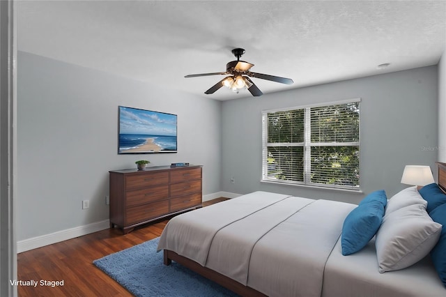 bedroom with dark wood-type flooring, ceiling fan, and a textured ceiling