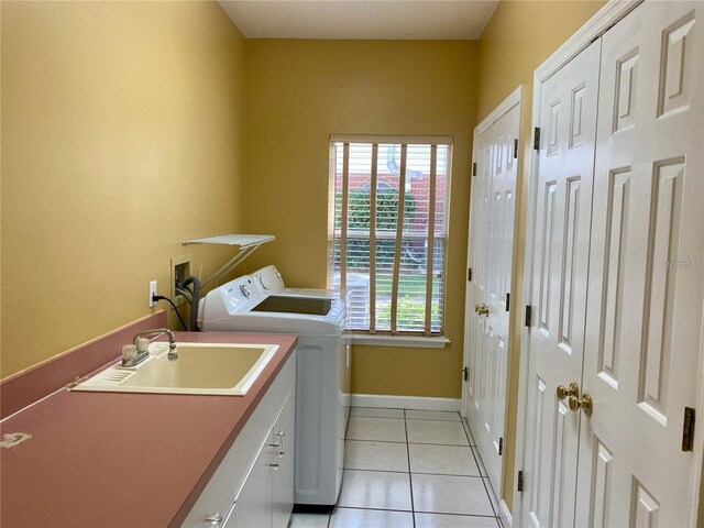 laundry room featuring light tile patterned flooring, cabinets, independent washer and dryer, and sink