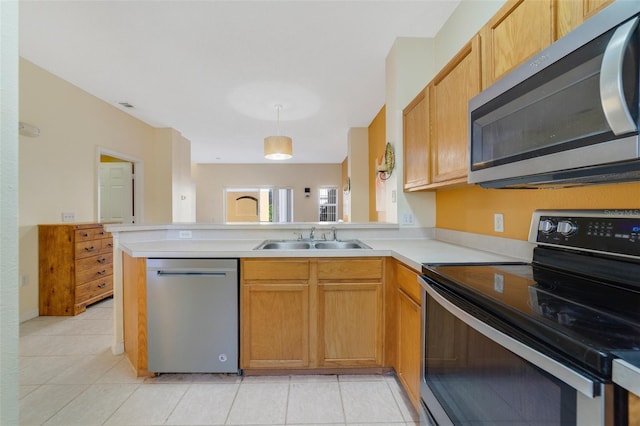 kitchen featuring kitchen peninsula, appliances with stainless steel finishes, light tile patterned flooring, pendant lighting, and sink