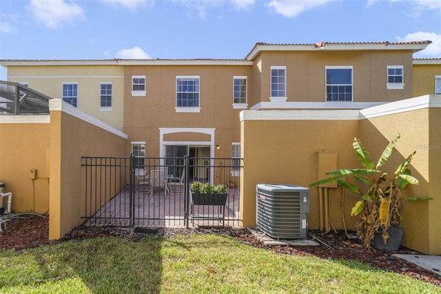 back of property featuring a lawn and central AC unit