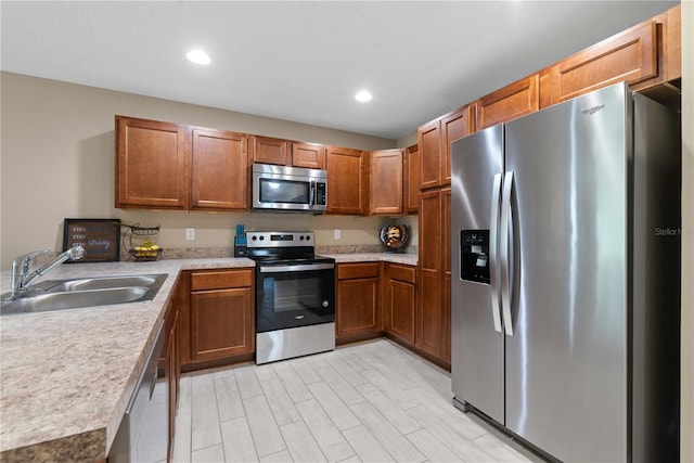 kitchen featuring stainless steel appliances, sink, and light wood-type flooring