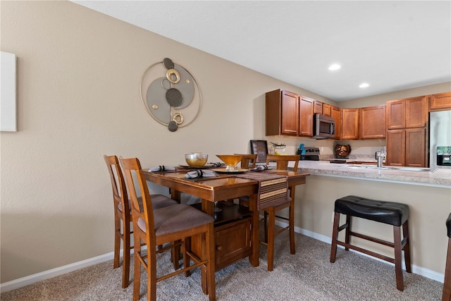 carpeted dining space with sink