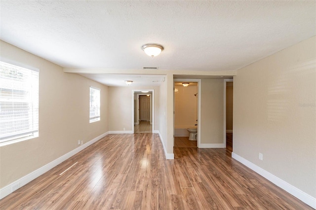 spare room featuring a textured ceiling and hardwood / wood-style floors