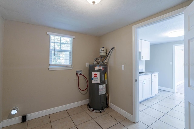 laundry room featuring water heater, a textured ceiling, washer hookup, and light tile patterned floors