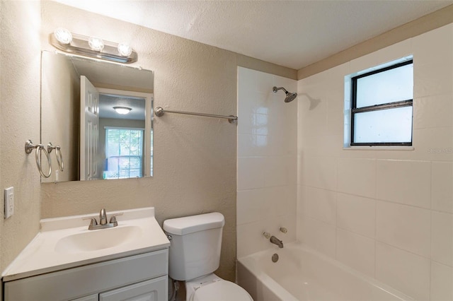 full bathroom with vanity, tiled shower / bath combo, toilet, and a textured ceiling