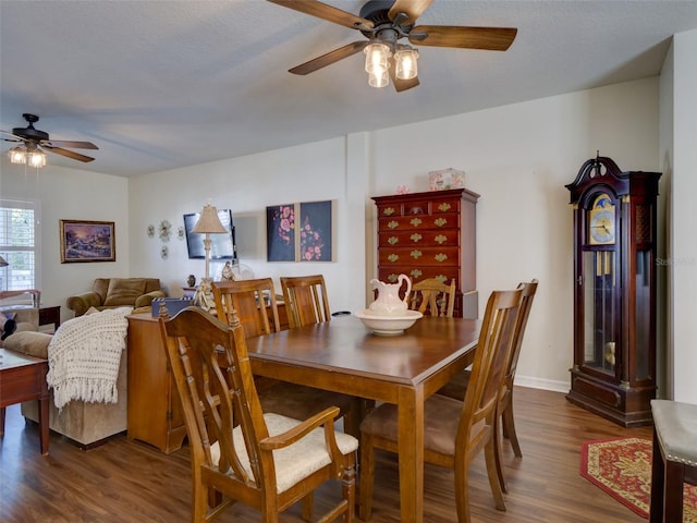 dining space featuring wood finished floors, a ceiling fan, and baseboards