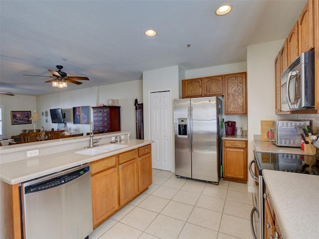 kitchen with light tile patterned flooring, a sink, open floor plan, light countertops, and appliances with stainless steel finishes