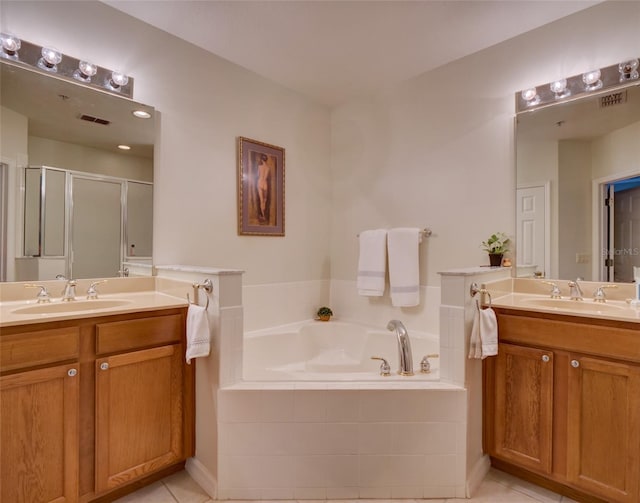 full bath featuring two vanities, a garden tub, a sink, and a shower stall