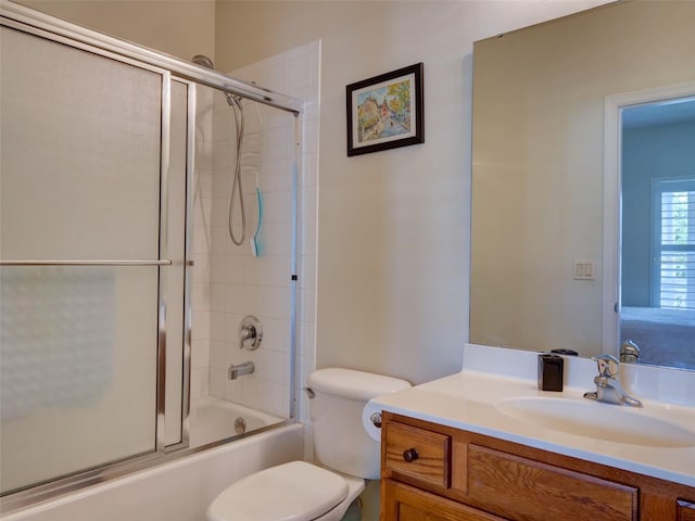 bathroom featuring toilet, bath / shower combo with glass door, and vanity