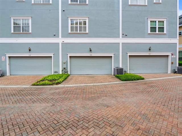 garage featuring cooling unit and decorative driveway